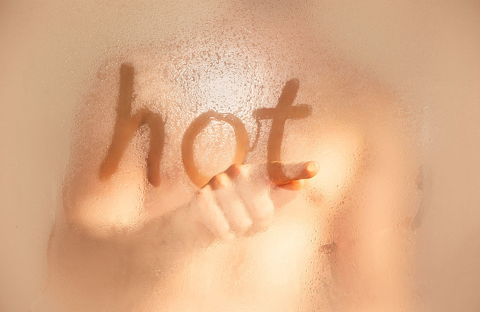 Magdeburg zeigt Wärme Man schreibt "hot" an eine verdampfte Duschwand