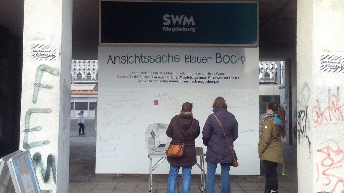 Zwei Frauen lesen Meinungswand zum neuen Blauen Bock