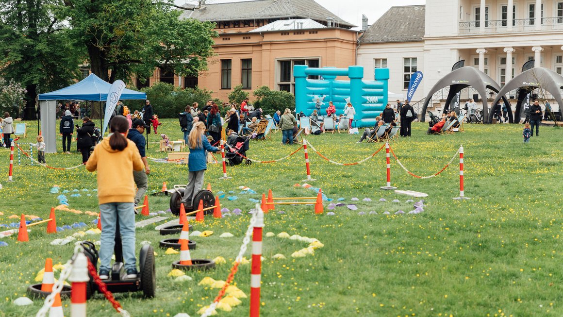 Kinder im Segway-Parkour auf der Grünen Messe, Besucher und Hüpfburg im Hintergrund