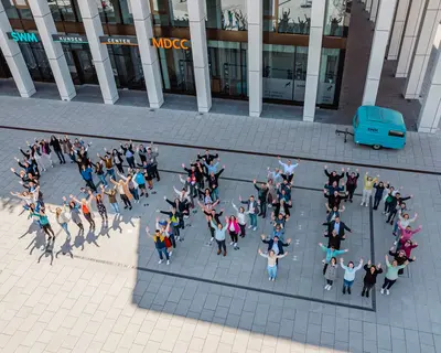 SWM Mitabeiter:innen stehen vor dem Gebäude und bilden den Schriftzug "Love MD"