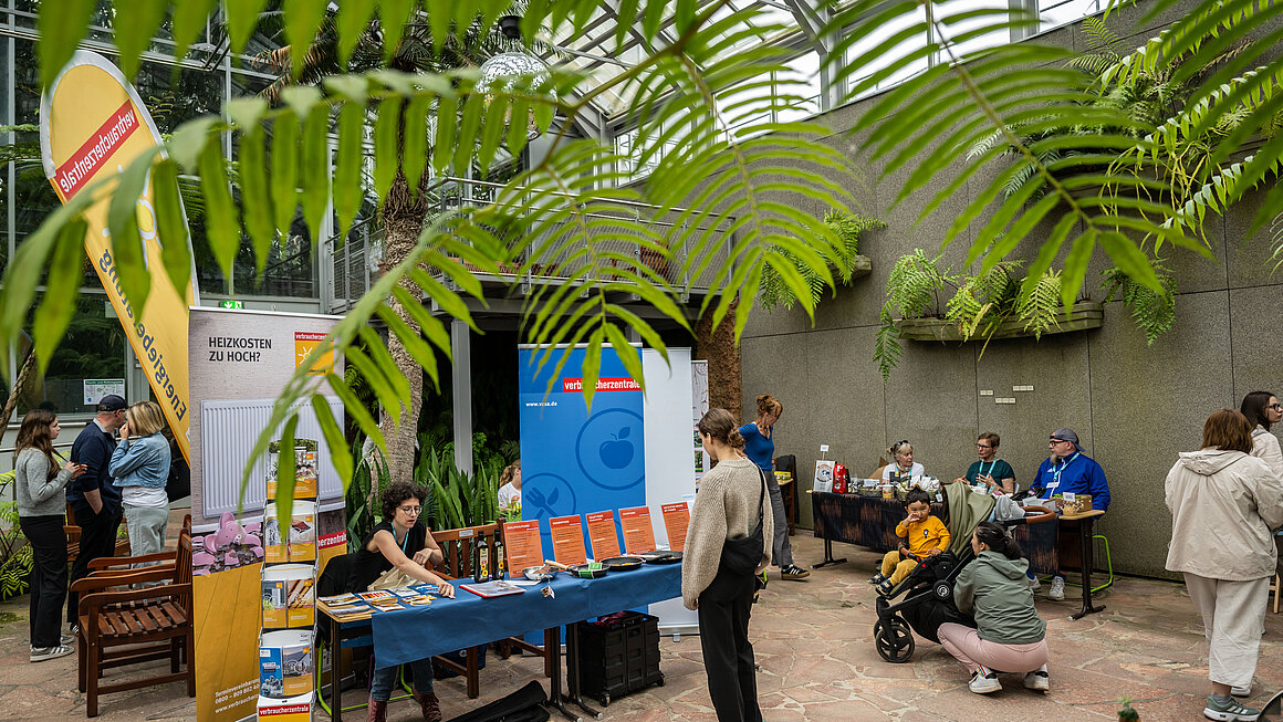 Blick in das Gewächshaus mit Blick auf den Stand der Verbraucherzentrale