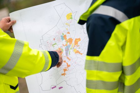 Zwei SWM Mitarbeiter schauen auf einen Wärmeplan