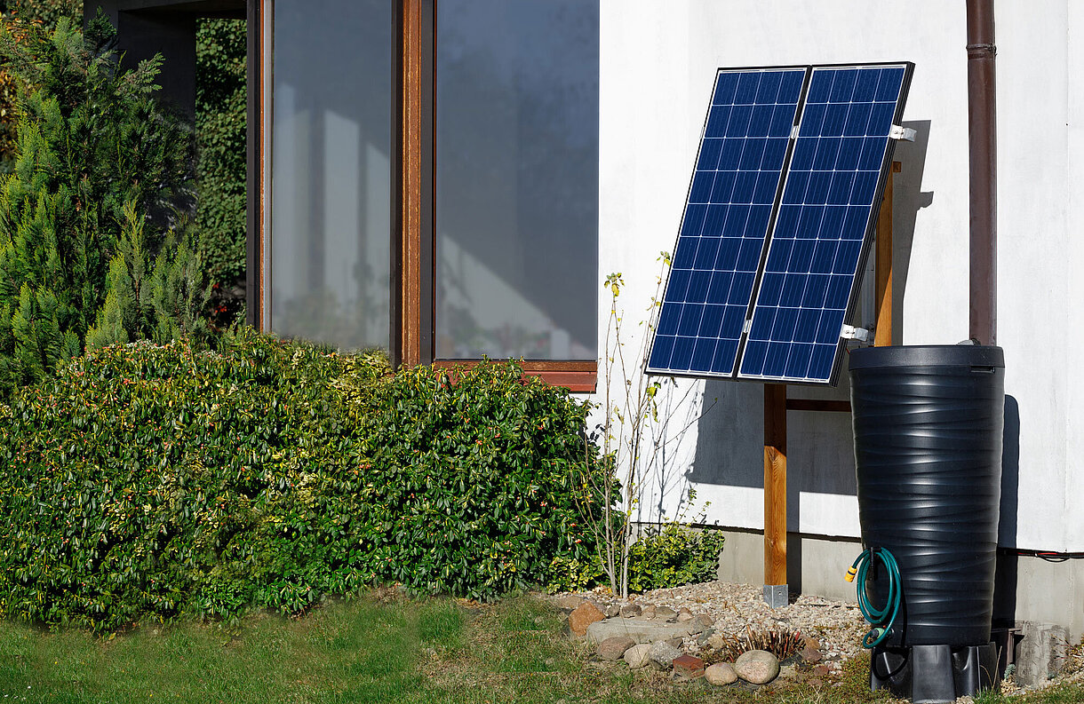Mini-Photovoltaik-Anlage an einer Hauswand an einer Holzkonstruktion