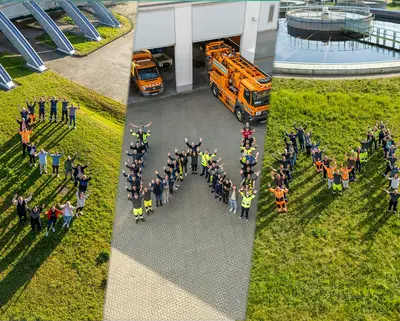 Mitarbeiter bilden den SWM Schriftzug - Ansicht von oben