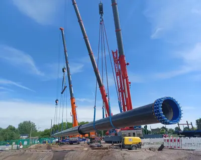 Schwerlastkrane heben Wasserleitung