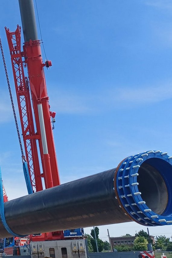 Schwerlastkrane heben Wasserleitung