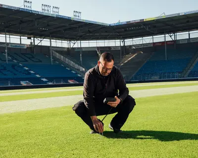 Stadiongärtner Andreas Pfeiler prüft den Rasen in der MDCC-Arena