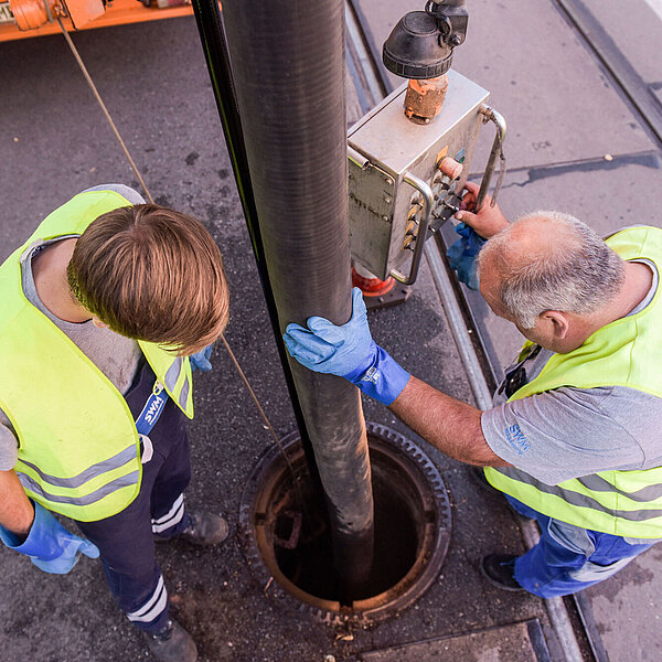 Zwei Mitarbeiter der Abwassertechnik arbeiten zusammen.