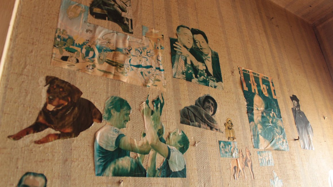 Ausgeschnittene Poster an Wand Alte Blümchentapete im alten Blauen Bock