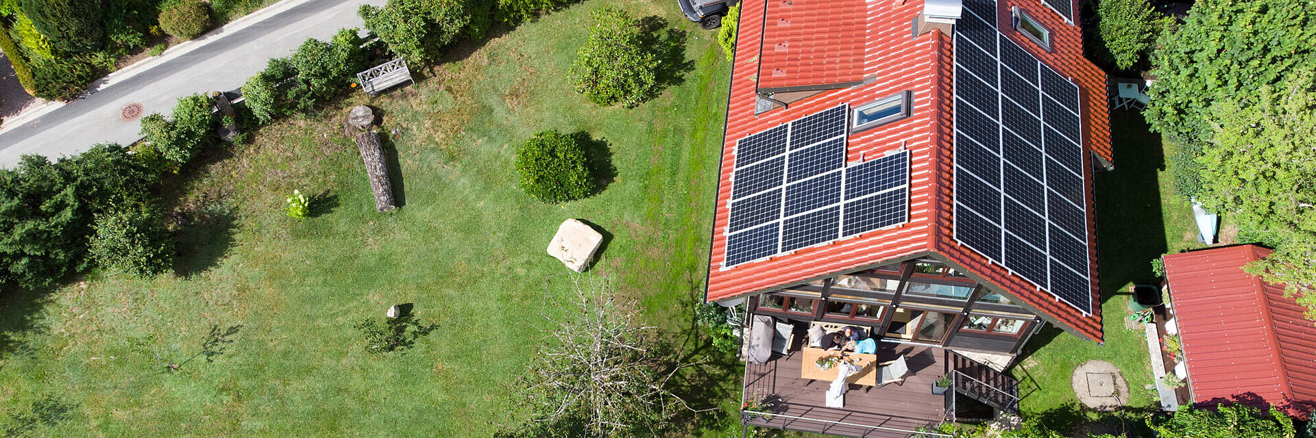 Blick von oben auf ein Wohnhaus mit Photovoltaik-Anlage auf dem Dach