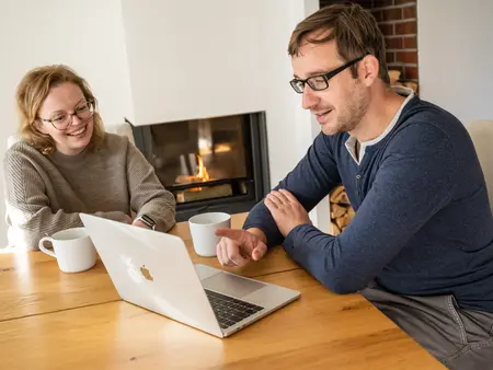 Kunden werben Kunden, Frau und Mann am Laptop im Wohnzimmer