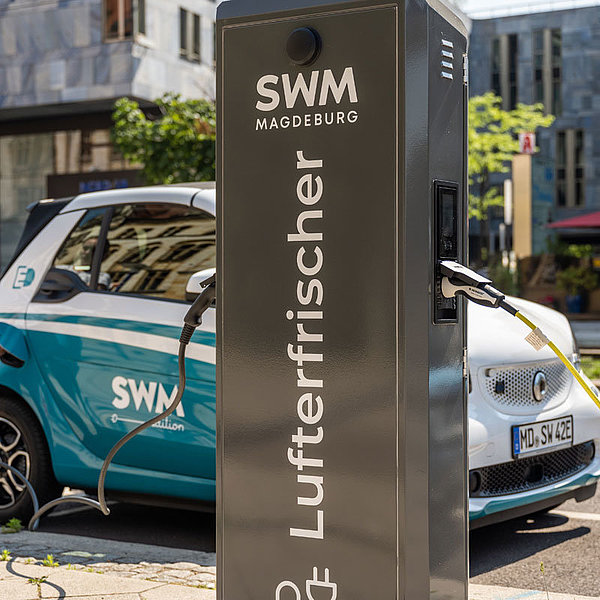 Frau lädt an Ladesäule in Magdeburger Innenstadt