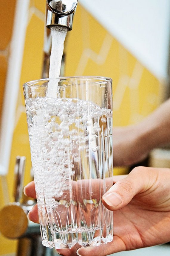 Trinkglas wird an Wasserhahn befüllt