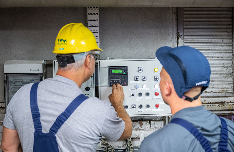 SWM Mitarbeiter betätigen Schaltanlage