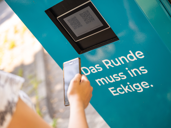 SMS laden Frau scannt den QR-Code an der Ladesäule