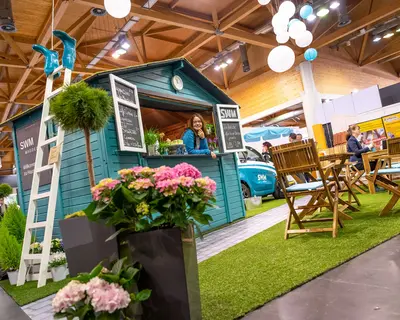 SWM Promotorin guckt aus der SWM Hütte auf der Magdeburger Messe 